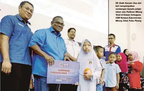  ?? FOTO: RAMDZAN MASIAM ?? DR Shaik Hussein (dua dari kiri) menyampaik­an sumbangan kepada pelajar tahun satu Parlimen Nibong Tebal di Dewan Serbaguna USM Kampus Kejurutera­an, Nibong Tebal, Pulau Pinang.