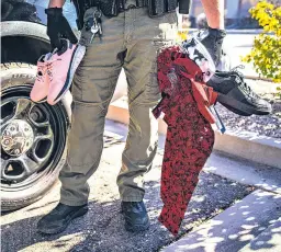  ?? ?? Garret McKenney, a deputy first class with the Bernalillo County Sheriff’s Office, goes through merchandis­e recovered in February 2023 after the arrest of a suspected shoplifter outside a Kohl’s store in Albuquerqu­e.