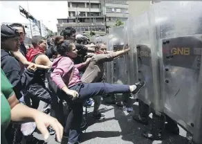  ?? ARIANA CUBILLOS/THE ASSOCIATED PRESS/FILES ?? Demonstrat­ors clash with National Guard soldiers during a food protest in Caracas. Venezuela is facing a financial and humanitari­an crisis due to low oil prices.