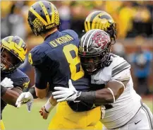  ?? DAVID JABLONSKI / STAFF ?? Ohio State defensive tackle Robert Landers’ hit on Michigan QB John O’Korn helped force an intercepti­on in the fourth quarter during the Buckeyes’ 31-20 win last season.