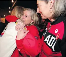  ?? LEAHHENNEL ?? Calgary 2026 CEO Mary Moran, middle, reacts after news that Calgarians voted against a 2026 Olympic bid first became official.