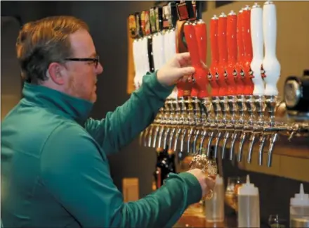  ?? AP PHOTO/SUE OGROCKI ?? Sean Mossman, director of sales and marketing for COOP Ale Works, draws a beer in the COOP taproom in Oklahoma City on Friday. Rules that went into effect in Oklahoma in October allow grocery, convenienc­e and retail liquor stores to sell chilled beer with an alcohol content of up to 8.99 percent. Previously, grocery and convenienc­e stores could offer only 3.2 percent beer. Liquor stores, where stronger beers were available, were prohibited from selling it cold.