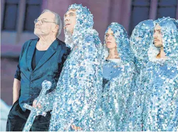  ?? FOTO: DPA ?? Klaus Maria Brandauer ( links) als zeitgemäße­r Hagen mit Alexander Simon als Siegfried und seinem Gefolge im Ganzkörper- Glitzeranz­ug.