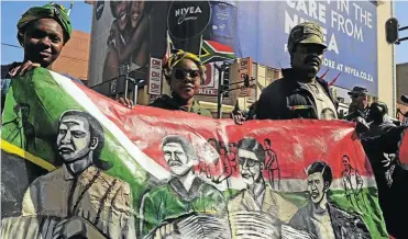  ?? Picture: Thulani Mbele ?? Marchers hold up a painting depicting Rahima Moosa, Lillian Ngoyi, Helen Joseph and Sophia de Bruyn during a march commemorat­ing Women’s Month. The four women led thousands of other women to the Union Buildings to protest against pass laws on August 9 1956.