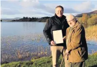  ??  ?? Honour MP Stephen Kerr presents a framed copy of Hansard to Observer columnist Keith Graham