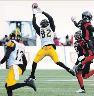  ?? PHOTOS BY SEAN KILPATRICK THE CANADIAN PRESS ?? Hamilton Tiger-Cats’ Justin Buren leaps to make a catch as Ottawa Redblacks’ Jonathan Rose, right, just misses the ball during first-half action.