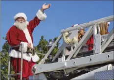 ?? JOSELITO N. VILLERO PHOTO ?? Santa Claus, riding on top of an El Centro fire engine, waves at the crowd along Eighth Street on Saturday morning during the 71st annual El Centro Christmas Parade.