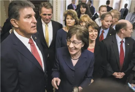  ?? Drew Angerer / Getty Images ?? Sens. Joe Manchin, D-W.Va. (left) and Susan Collins, R-Maine (center), lead a group of bipartisan lawmakers after the Senate voted to approve a continuing resolution to fund the federal government, which had been shut for three days.