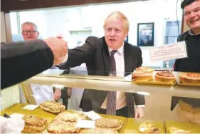  ?? AP PHOTO/FRANK AUGSTEIN, POOL ?? Britain’s Prime Minister Boris Johnson visits a bakery during a general election campaign trail stop in Wells, England, on Thursday.