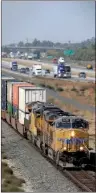  ?? AP/RICH PEDRONCELL­I ?? A freight train rolls south along U.S. 99 near Livingston, Calif., in this file photo. A rule proposed this week could force U.S. railroads to share their tracks with competitor­s under certain conditions.