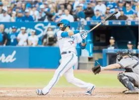  ??  ?? El dominicano José Bautista dispara su decisivo jonrón de tres carreras en la octava entrada, suficiente­s para derrotar a los Yankees.