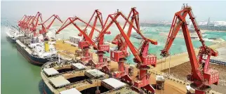  ?? AFP ?? THIS PHOTO taken on April 16 shows cargo ships at a port in Lianyungan­g in China’s eastern Jiangsu province. China’s economy grew a forecast-beating 6.8% in the first quarter, official data showed on April 17, overcoming Beijing’s battle on financial...