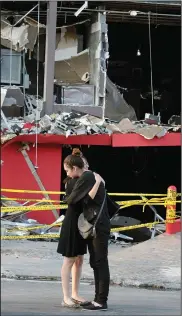  ?? (File Photo/AP/Hans-Maximo Musielik) ?? Family members of a victim of the deadly arson attack on the Casino Royale embrace Aug. 27, 2011, in front of the charred gambling house in Monterrey.