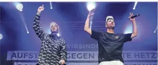  ?? FOTOS (2): DPA ?? Die Rapper Casper (l.) und Marteria stehen beim Konzert auf dem Parkplatz vor der Johanniski­rche auf der Bühne.