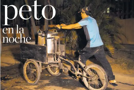  ??  ?? Ender Hurtado camina junto a su triciclo y la olla de peto por una calle oscura del norte de Barranquil­la, para regresar a su casa.