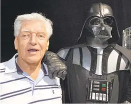  ?? THIERRY ZOCCOLAN AFP VIA GETTY IMAGES ?? British actor Dave Prowse, who played the character of Darth Vader in the first “Star Wars” trilogy, poses with a fan dressed up in a Darth Vader costume during a “Star Wars” convention in Cusset, France, in 2013.