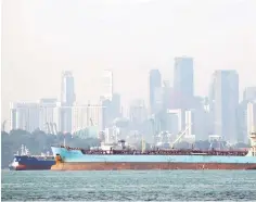  ??  ?? Oil tankers pass the skyline of Singapore. The Board of Investment of Sri Lanka said constructi­on would begin this weekend on the refinery and storage facility jointly financed by Oman’s Ministry of Oil and Gas and a Singapore-registered company. — Reuters photo