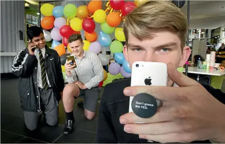  ?? ROSS GIBLIN/STUFF ?? Wellington College students, from left, Rupesh Kanji, Connor Larsen-Cross and Ollie Michie are selling cellphone popsockets to help the Sexual Abuse Prevention Network, in a bid to restore mana to their school.