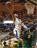  ?? Justin K. Aller / Getty Images ?? West Virginia’s Jevon Carter soars to the basket over Baylor’s helpless Jo Lual-Acuil Jr. during the Mountainee­rs’ overpoweri­ng performanc­e Tuesday night.