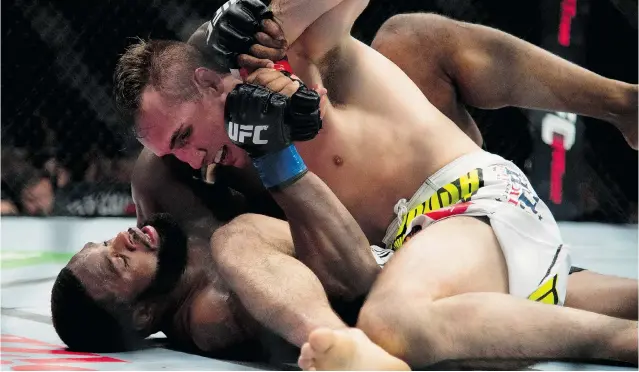 ?? JONATHAN HAYWARD/THE CANADIAN PRESS FILES ?? Rory MacDonald pins Tyron Woodley, of the United States, to the mat during the welterweig­ht bout at UFC 174 in Vancouver this year. MacDonald marked his return to his home province with a victory.