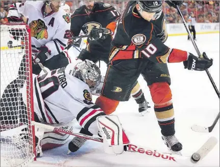  ?? Robert Gauthier Los Angeles Times ?? CHICAGO GOALIE Corey Crawford gets his stick on the puck, denying Corey Perry late in the third period as the Ducks tried in vain to rally. The Ducks dominated in shots and hits, but Chicago took a 4-0 lead and held on to reach the Stanley Cup Final.