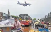  ?? PTI PHOTO ?? An aircraft flies over as commuters drive through a waterlogge­d road after premonsoon shower in Mumbai.