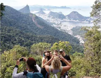  ??  ?? People take photos as they walk along a hiking trail - part of a projected 8,000-kilometer trail across Brazil.