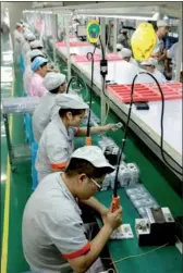  ?? ZHOU SONGLIN / FOR CHINA DAILY ?? Workers process electronic products at a production plant in