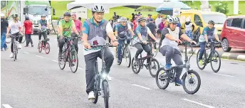  ?? — Photo by Roystein Emmor ?? Dr Abdul Rahman (front, le ) and Hilmy, on his le , seen with other cyclists a er the programme launch at the Heroes Monument Park in Kuching.