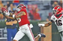  ?? CRIMSON TIDE PHOTOS ?? Alabama receiver John Metchie III hauls in a 40-yard touchdown reception to open up the scoring during last Saturday’s 41-24 win over Georgia. The Crimson Tide will visit Tennessee today.