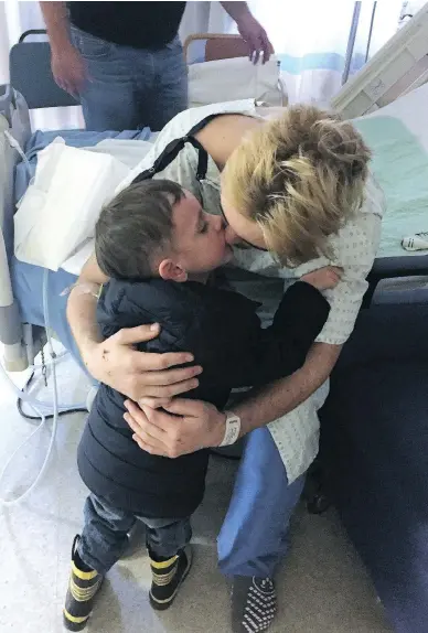  ?? JASON KEATING/FOR POSTMEDIA NEWS ?? Brayden Camrud, a member of the Humboldt Broncos who survived Friday’s horrific bus crash, gets a hug from his cousin Jaxson Keating on Monday at Royal University Hospital in Saskatoon. Twelve survivors remain in the hospital — four are in critical...