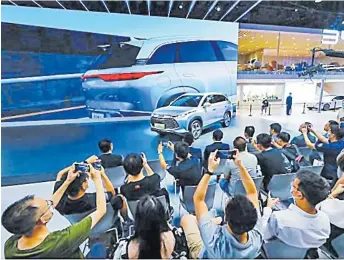  ?? Picture: SUPPLIED ?? Visitors and press take photos of a car of BYD, China’s new energy vehicle (NEV) manufactur­er, at the Chengdu Motor Show 2022 in Chengdu, capital of southwest China’s Sichuan Province on August 26, 2022.