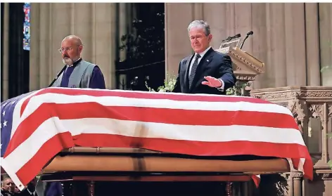  ?? FOTO: REUTERS ?? Ex-Präsident George W. Bush legt nach seiner Trauerrede eine Hand auf den mit dem Sternenban­ner verhüllten Sarg seines Vaters.