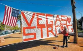  ?? THE ASSOCIATED PRESS ?? Las Vegas resident Nancy Cooley signs on Thursday a Vegas Strong banner honoring the victims of Sunday’s mass shooting in Las Vegas in which a gunman opened fire on an outdoor music concert, killing dozens and injuring hundreds.