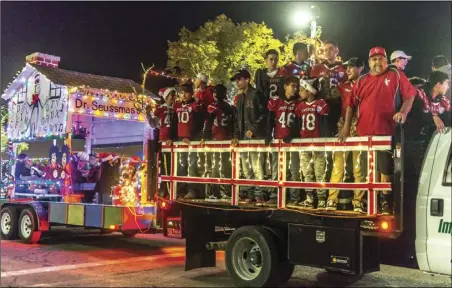  ?? PHOTO VINCENT OSUNAL ?? The Imperial Youth Football Pee Wee team, which recently competed at the AYF National Championsh­ips in Orlando, Fla., rides on the Imperial County Sheri ’sO ce float during the 16th annual Parade of Lights held Friday night in Imperial.