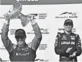  ??  ?? Scott Dixon hoists the trophy after winning the IndyCar race in Toronto on Sunday.