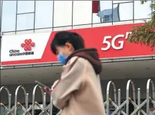  ?? HOU YU / CHINA NEWS SERVICE ?? A pedestrian passes a China Unicom branch in Beijing on Wednesday.