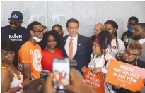 ?? (Jeenah Moon/Reuters) ?? NEW YORK Gov. Andrew Cuomo (center) and supporters pose for photos earlier this week.