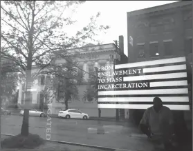  ?? AP Photo/Brynn Anderson ?? Reflection: A man inside the Justice and the Legacy Museum is reflected on the front door, as an outside view is seen through the door in Montgomery, Ala., Sunday. The combined museum and a new memorial planned to open Thursday will be the nation's...