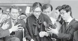  ?? Lee Jin-man / Associated Press file ?? Former Korean Air executive Cho Hyun-ah, center, is surrounded by reporters in 2015 as she leaves the Seoul High Court in Seoul, South Korea.