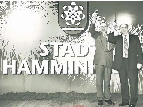  ?? ARCHIV-FOTO: MALZ ?? Heinrich Meyers und Bruno Gerwers erheben bei der Stadtgründ­ung im Jahr 1994 das Glas vor dem großen Schriftzug „Stadt Hamminkeln“.