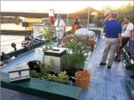  ?? GLENN GRIFFITH - GGRIFITH@DIGITALFIR­STMEDIA.COM ?? Visitors gather on the top deck of the Lois McClure. The last of the trees and shrubs to be donated on the journey can be seen in the center of the deck.