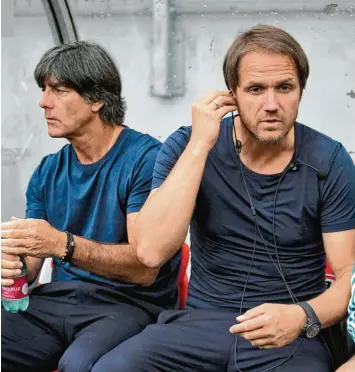  ?? Foto: ?? „Kannst du mich hören?“: Während des Testspiels gegen Österreich haben die Co Trainer Thomas Schneider (rechts, links Joa chim Löw) und Thomas Sorg (saß auf der Tribüne) von neuen technische­n Möglichkei­ten Gebrauch gemacht.