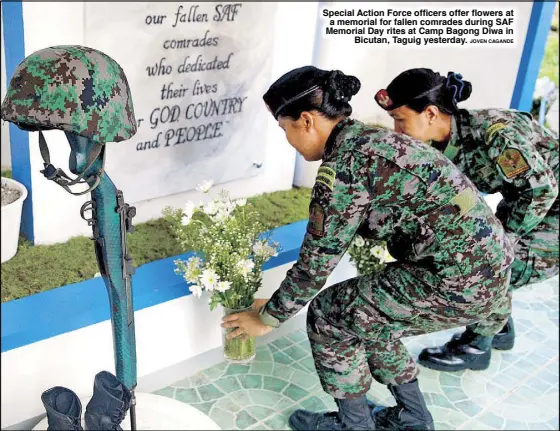  ?? JOVEN CAGANDE ?? Special Action Force officers offer flowers at a memorial for fallen comrades during SAF Memorial Day rites at Camp Bagong Diwa in
Bicutan, Taguig yesterday.