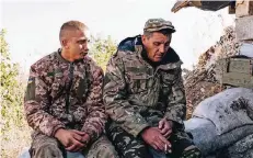  ??  ?? Zwei Soldaten der ukrainisch­en Armee sitzen bei einer Zigaretten­pause auf den Sandsäcken ihrer Stellung an der Front nahe dem Flughafen von Donezk.