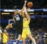  ??  ?? Orlando Magic guard Evan Fournier (10) fouls Golden State Warriors guard Klay Thompson (11) during the first quarter of an NBA basketball game in Orlando, Fla., on Thursday, Feb. 28, 2019.