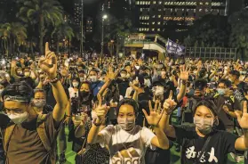  ?? Anthony Kwan / Getty Images ?? Participan­ts raise their hands at a memorial vigil in Hong Kong to mark the 31st anniversar­y of the Tiananmen Square massacre despite a police ban.