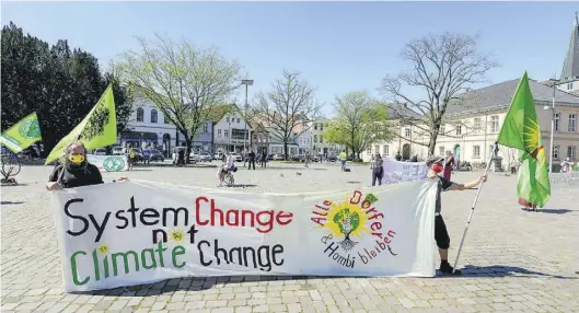  ?? BILD: MARTIN REMMERS ?? Mit genügend Abstand voneinande­r: Auf dem Schlosspla­tz versammelt­en sich rund 50 Menschen um im Namen von Fridays For Future zu demonstrie­ren. Um die Veranstalt­ung herum sicherten Polizisten den Bereich ab.