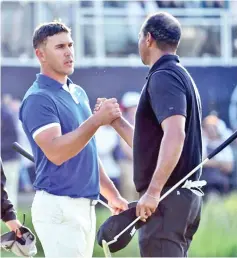  ??  ?? Tiger Woods (R) shakes hands with 36-hole leader Brooks Koepka after their second rounds Friday at the PGA Championsh­ip. — AFP photo