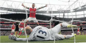  ?? Picture: REUTERS ?? HOLDING ON: Theo Walcott celebrates as Shkodran Mustafi (not pictured) put their second goal past Manchester City’s Willy Caballero yesterday